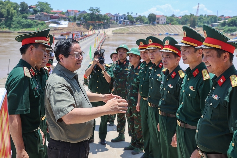 Thủ tướng động viên cán bộ, chiến sĩ đang vận hành cầu phao Phong Châu. Ảnh: VGP