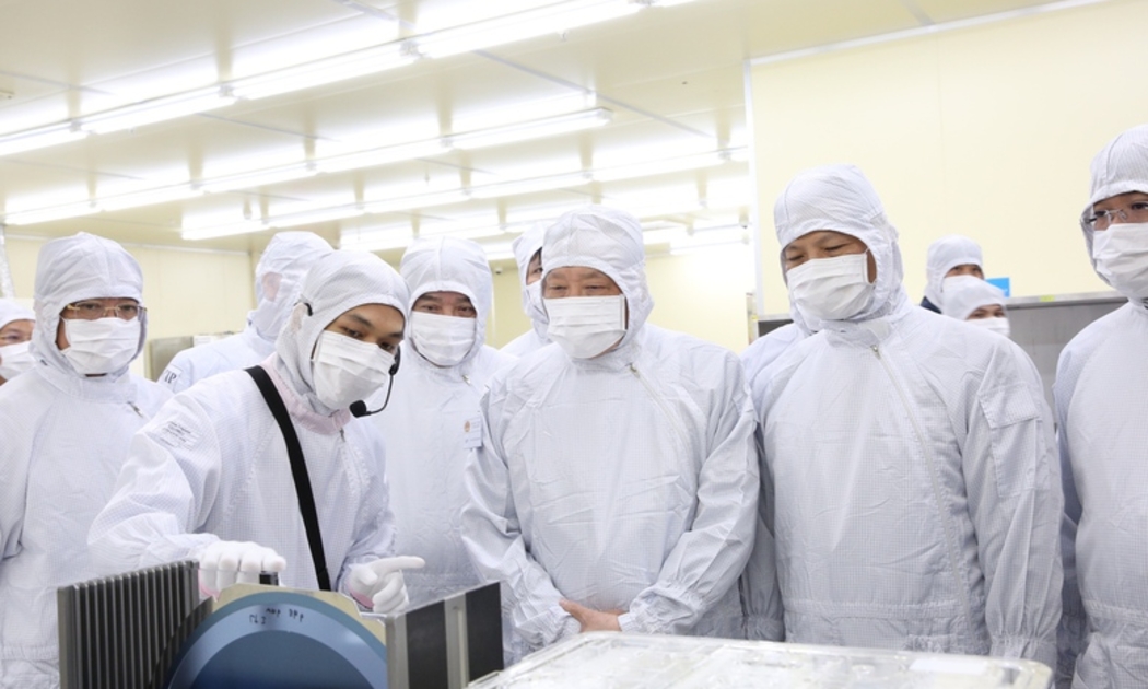 Phó Thủ tướng Thường trực Chính phủ Nguyễn Hòa Bình nghe giới thiệu các sản phẩm khi thăm Công ty TNHH Hana Micron Vina - Ảnh: VGP. 