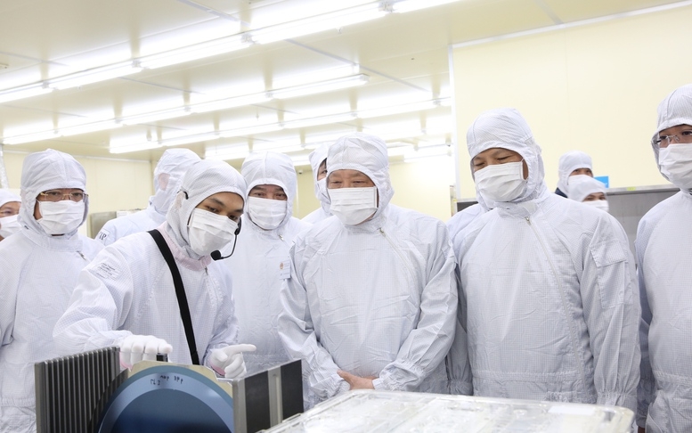 Phó Thủ tướng Thường trực Chính phủ Nguyễn Hòa Bình nghe giới thiệu các sản phẩm khi thăm Công ty TNHH Hana Micron Vina - Ảnh: VGP. 