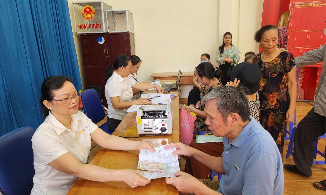 Chi trả chế độ an sinh xã hội cho người dân tại Hà Nội. Ảnh: TH.