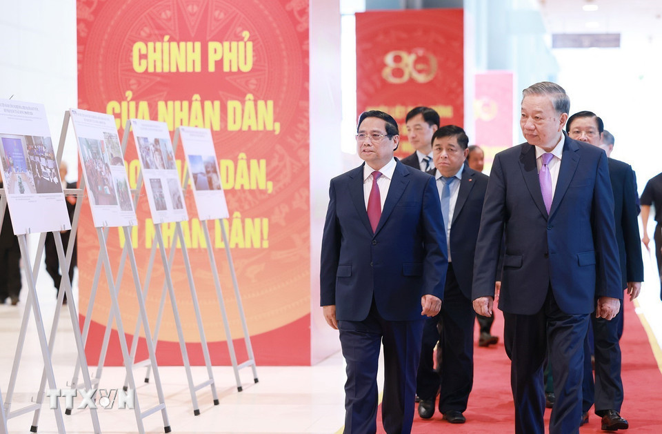 Tổng Bí thư Tô Lâm và Thủ tướng Phạm Minh Chính cùng các đại biểu tham quan trưng bày ảnh về hoạt động của Chính phủ qua các thời kỳ do TTXVN thực hiện. Ảnh: TTXVN