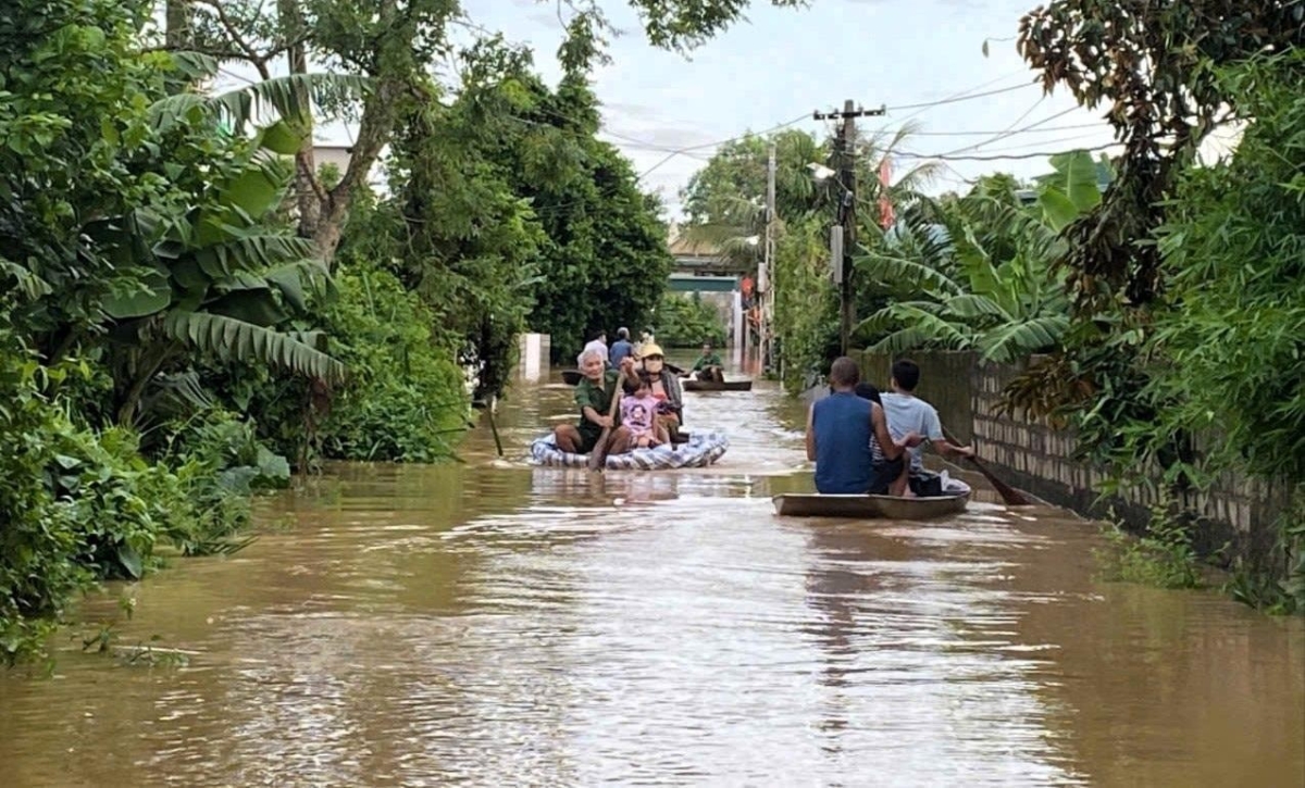 Nhiều người dân phải dùng thuyền để di chuyển vì đường sá chìm trong nước.