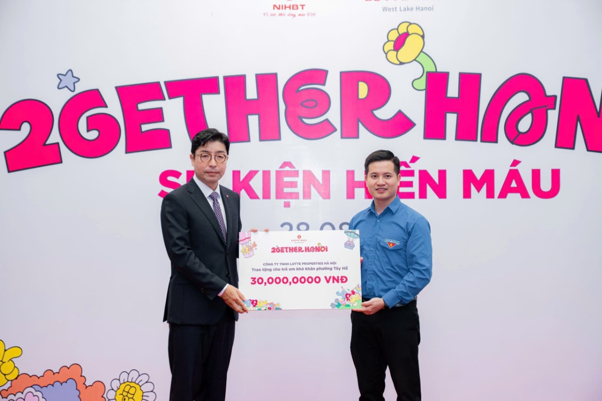 Tổng giám đốc Lotte Properties Hà Nội Kim Joon Young trao kinh phí hỗ trợ học sinh có hoàn cảnh khó khăn cho Chủ tịch Ủy ban MTTQ phường Tây Hồ Phạm Thế Vinh.