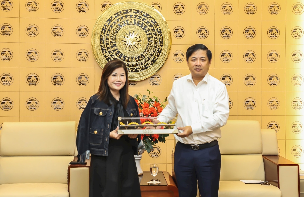 Chủ tịch UBND thành phố Lương Nguyễn Minh Triết (bên phải) tặng quà lưu niệm cho bà Linda Tan - Ảnh: Ngọc Phú. 