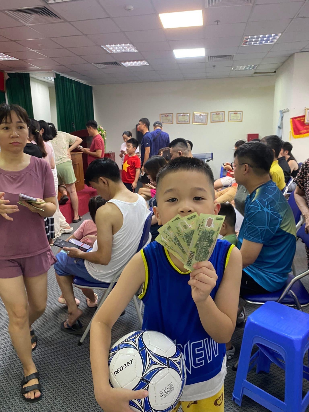 Một cháu bé&nbsp; ở chung cư Gemek (Tổ dân phố số 4) xã An Khánh háo hức cùng mẹ đến nhận tiền quà 2/9 cho cả gia đình.