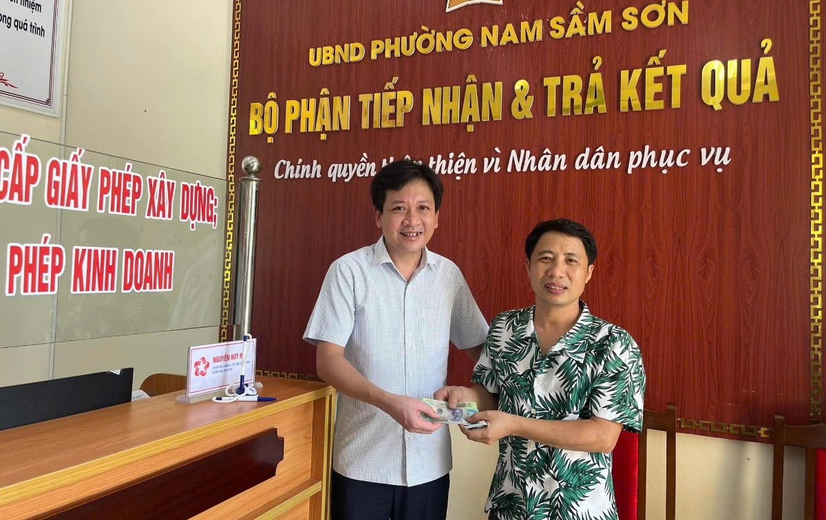 Chủ tịch UBND phường Nam Sầm Sơn Lê Hùng Sơn trao suất quà cho đại diện hộ dân đầu tiên đến nhận quà