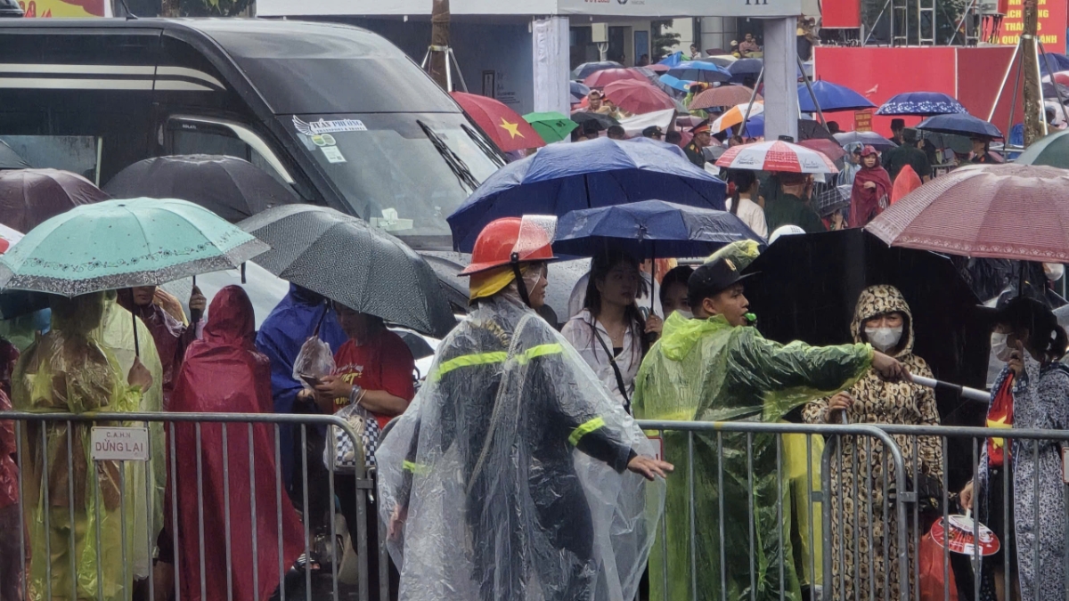 Nhiều người dân che ô, mặc áo mưa, quyết tì cho mình một vị trí thuận tiện để có thể chờ xem diễu binh.&nbsp;