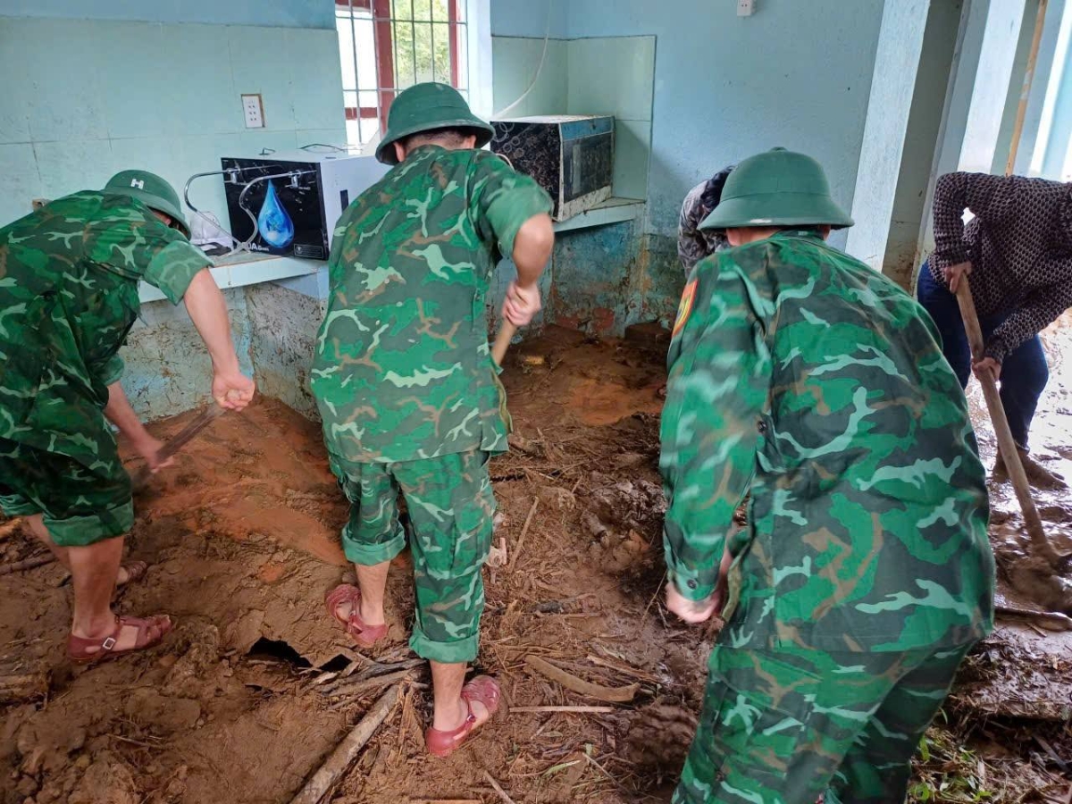 Các chiến sĩ biên phòng tích cực dọn dẹp bùn đất tràn vào các lớp học