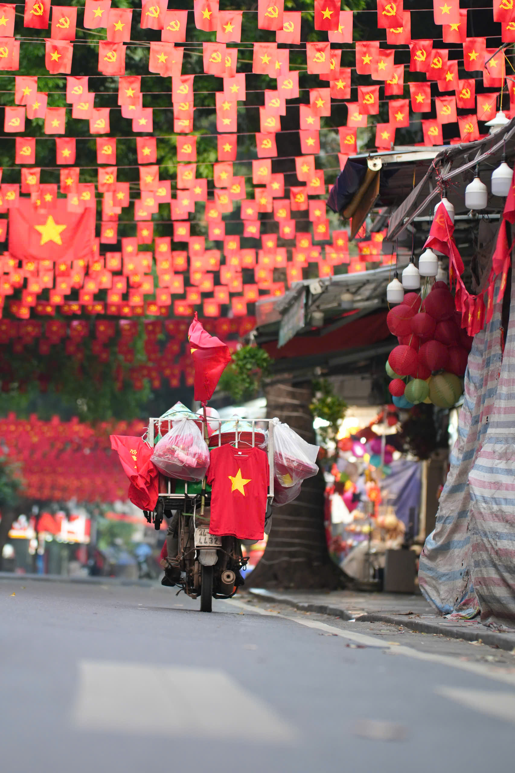 Tại Hà Nội những ngày này, từ những ngôi nhà nhỏ đến quán cà phê, từ các tuyến phố lớn tới ngõ nhỏ, đâu đâu cũng rực rỡ sắc đỏ của quốc kỳ. Những lá cờ treo nối tiếp nhau, đón gió tung bay như biến cả Hà Nội thành một bầu trời cờ hoa.