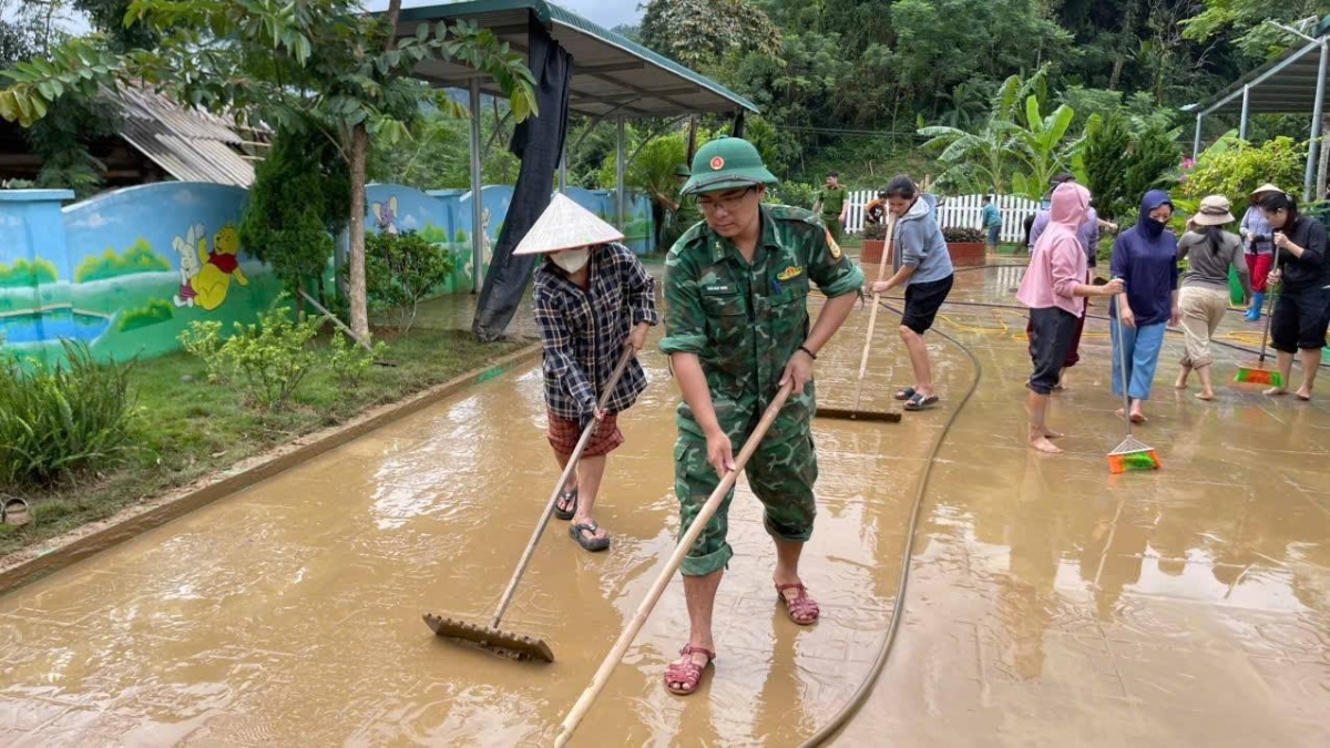 Giáo viên và lực lượng chức năng dọn dẹp bùn đất tại khuôn viên trường