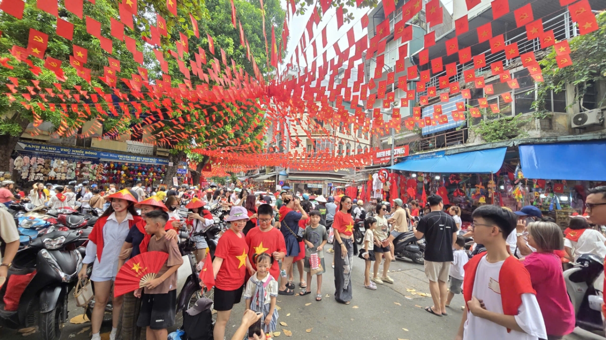Con phố Hàng Mã được “nhuộm đỏ” bởi hàng trăm lá cờ Tổ quốc, tạo nên một khung cảnh vô cùng ấn tượng. Các cửa hàng treo cờ, đèn lồng, bày bán những sản phẩm trang trí gắn liền với ngày lễ, khiến không khí trở nên sôi động và nhộn nhịp hơn thường ngày.