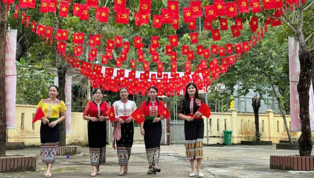 Những cô gái Thái ở xã Hùng Chân, tỉnh Nghệ An rạng rỡ dưới giàn trang trí cờ Đảng, cờ Tổ quốc rất đẹp mắt chào mừng ngày Tết Độc lập - Quốc khánh 2/9. Ảnh: Thanh Đức.