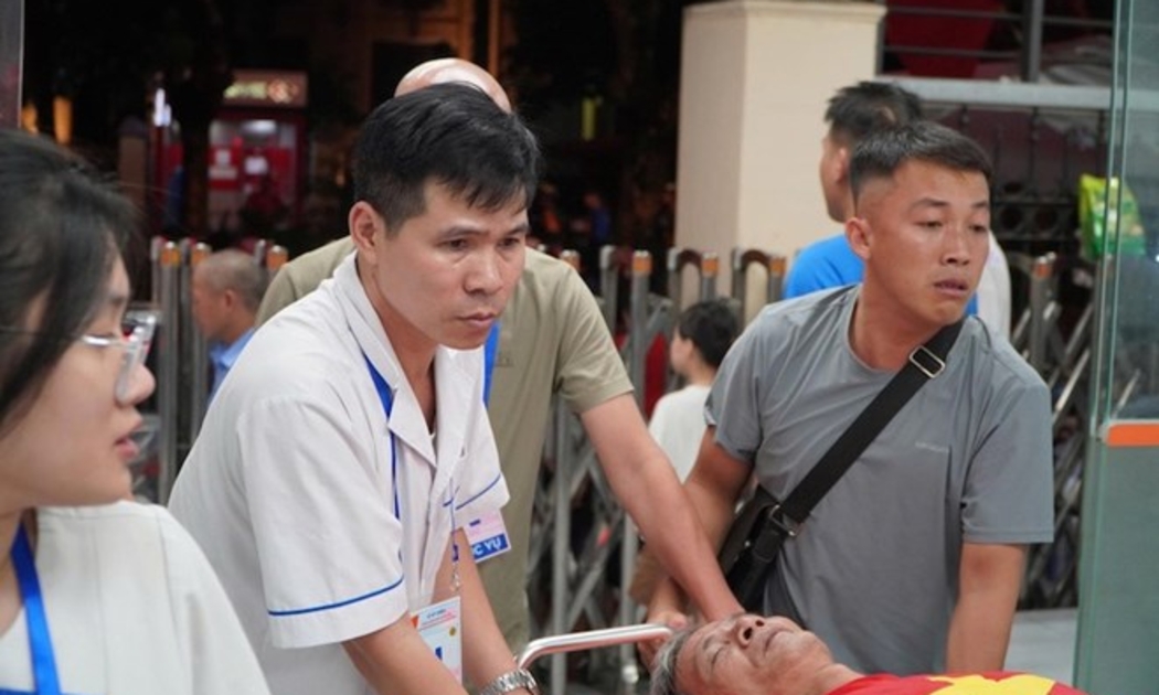 Các y bác sĩ đưa người dân chờ xem diễu binh vào cấp cứu tại Bệnh viện Đa khoa Xanh Pôn. Ảnh: Anh Đức.
