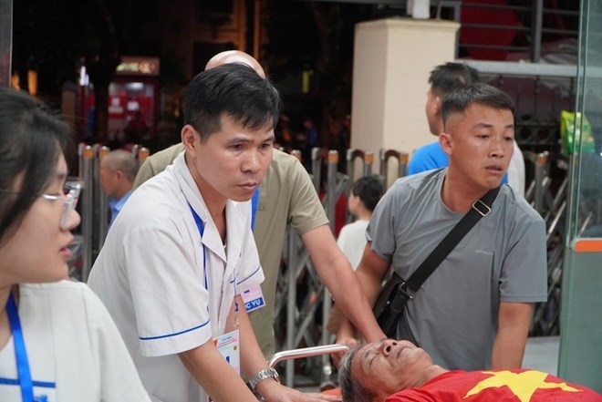 Các y bác sĩ đưa người dân chờ xem diễu binh vào cấp cứu tại Bệnh viện Đa khoa Xanh Pôn. Ảnh: Anh Đức.