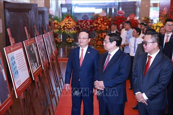 Thủ tướng Phạm Minh Chính tham quan trưng bày ảnh về quá trình hình thành và phát triển của Đài Tiếng nói Việt Nam. Ảnh: TTXVN.