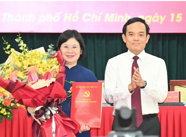 Bí thư Thành ủy TP.HCM Trần Lưu Quang trao quyết định cho bà Văn Thị Bạch Tuyết - Ảnh: SGGP.