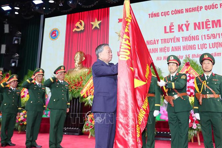 Tổng Bí thư gắn danh hiệu Anh hùng Lực lượng vũ trang nhân dân lên Quân kỳ Quyết thắng của Tổng cục Công nghiệp quốc phòng. Ảnh: TTXVN
