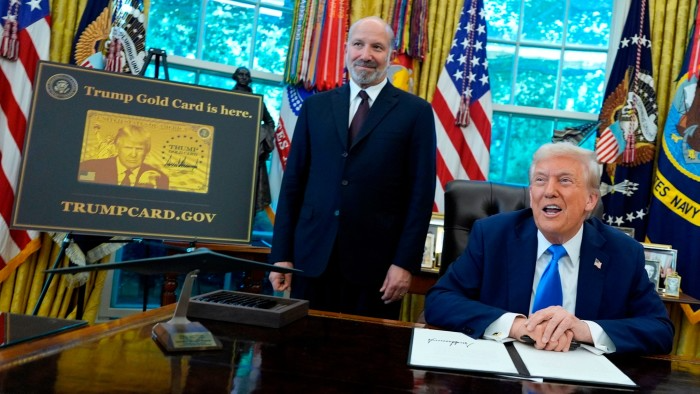 Tổng thống Mỹ Donald Trump phát biểu khi Bộ trưởng Thương mại Howard Lutnick đứng cạnh tấm áp phích Thẻ vàng Trump tại Văn phòng bầu dục - Ảnh: Retuers