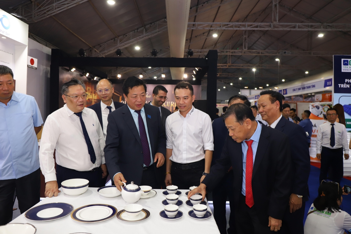 Bộ trưởng Bộ Xây dựng Trần Hồng Minh cùng các đại biểu tham quan, nghe giới thiệu về các sản phẩm trưng bày tại triển lãm.