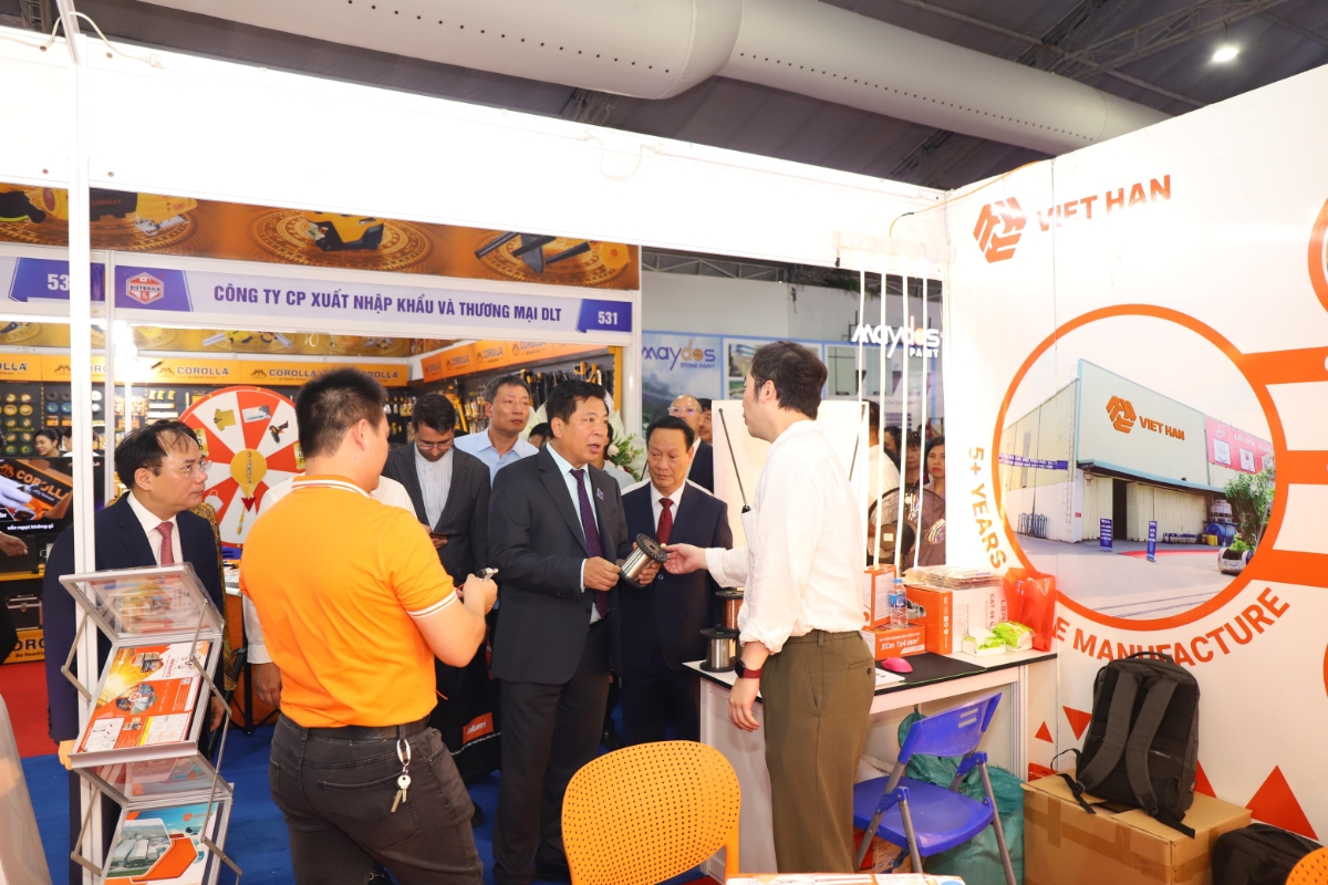 Bộ trưởng Bộ Xây dựng Trần Hồng Minh (áo vest, đứng giữa) tham quan các gian hàng tại triển lãm.