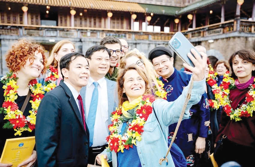 Lãnh đạo thành phố Huế chụp ảnh lưu niệm cùng du khách quốc tế tại Đại Nội. Ảnh: Hải Thanh