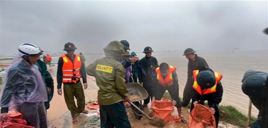 &nbsp;Cán bộ, chiến sĩ dầm mưa hộ đê sông Thị Long.