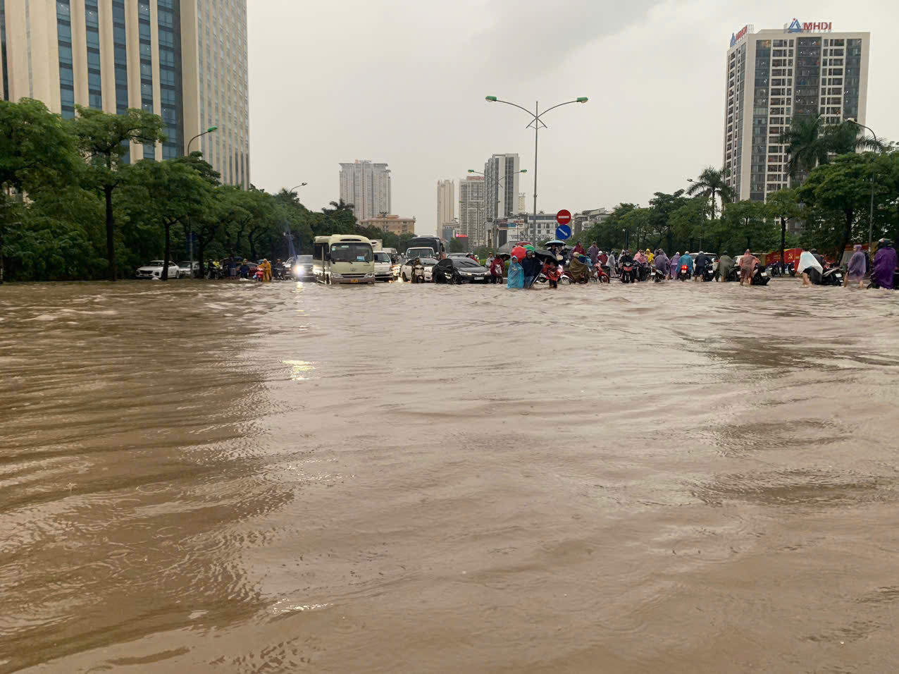 Nước ngập mênh mang tại khu vực gần sân vận động Mỹ Đình khiến khu vực này giao thông ùn tắc nghiêm trọng, người dân đi xe máy phải tắt máy dắt xe qua. Những chiếc xe ô tô gầm thấp cố tình lao qua điểm ngập này hầu hết đều chết máy phải gọi cứu hộ...