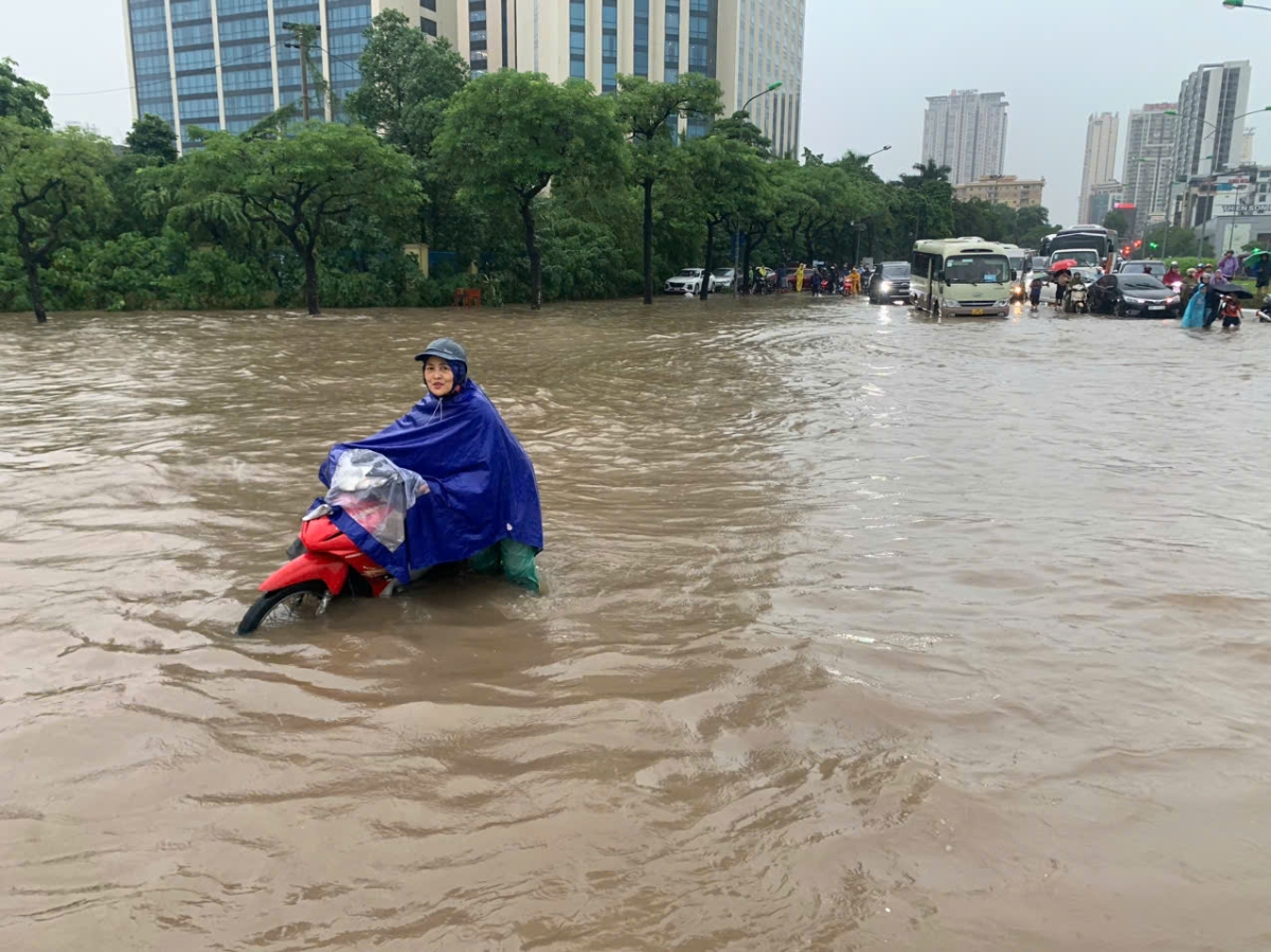 Người dân phải tìm mọi cách để vượt qua điểm ngập sâu. Tại đây đã có dịch vụ chở xe máy qua bằng xe cải tiến....