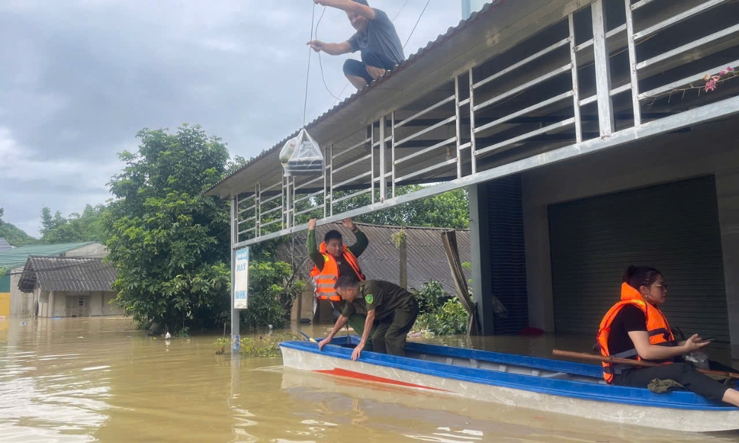 Công an xã Chiêm Hoá đưa đồ ăn, nước uống đến các hộ dân bị cô lập ở vùng ngập sâu. Ảnh: Bộ Công an.