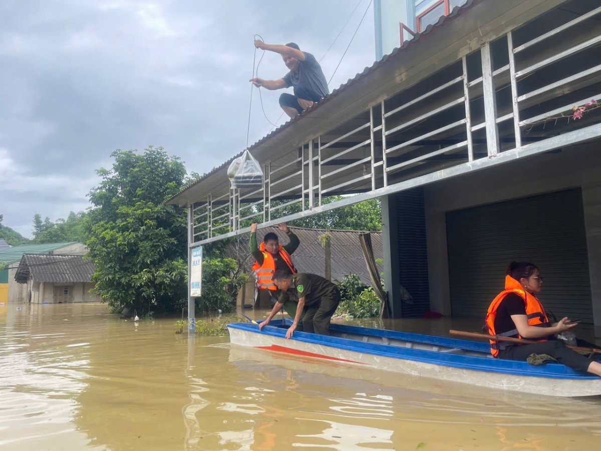 Công an xã Chiêm Hoá đưa đồ ăn, nước uống đến các hộ dân bị cô lập ở vùng ngập sâu. Ảnh: Bộ Công an.