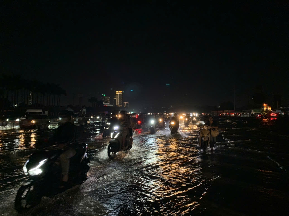 Là một trong những điểm ngập nặng nhất Hà Nội, đến khoảng 18h30 tại đây vẫn còn mênh mông nước. Do không có lực lượng chức năng điều tiết, hướng dẫn giao thông nên người dân đi xe máy đi vào điểm ngập sâu...
