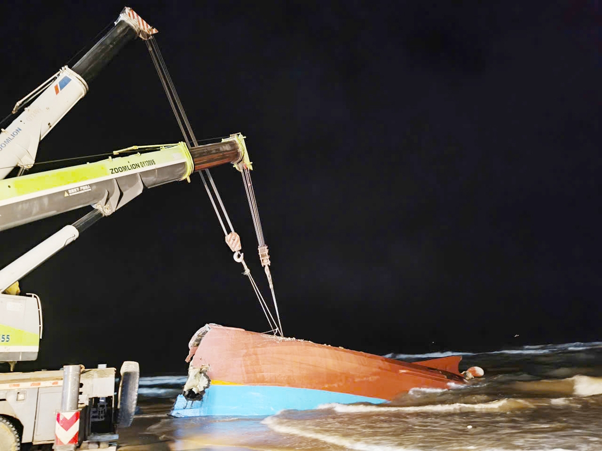 Các lực lượng chức năng tiến hành trục vớt tàu cá bị chìm tại bờ biển thôn Thanh Hải, xã Bắc Trạch