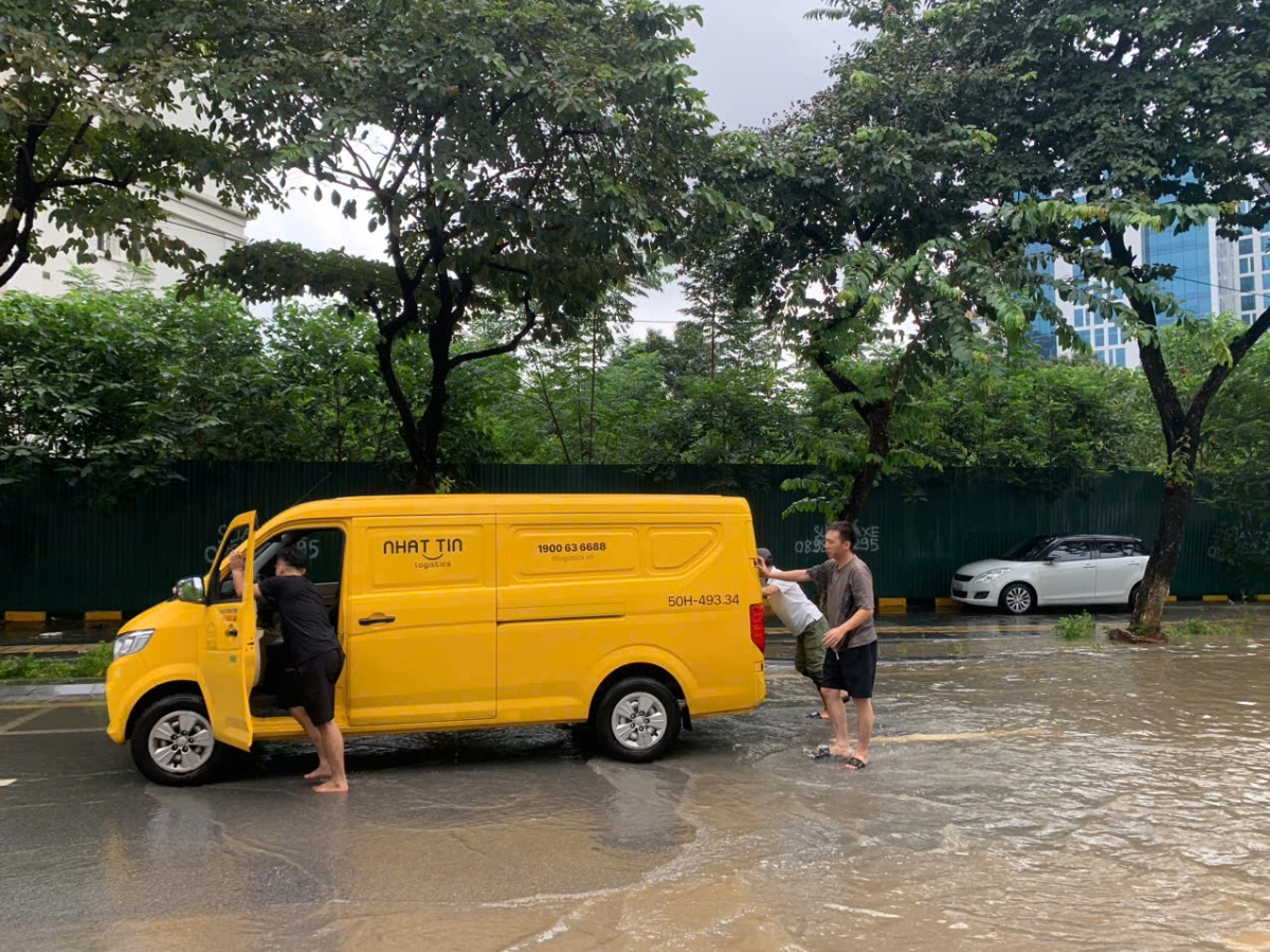 Người dân đẩy xe chết máy lên nơi cao ráo đề chờ xe cứu hộ tới ứng cứu...