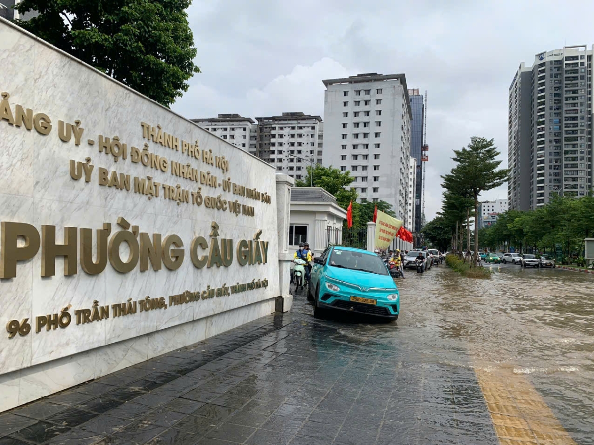 Nhiều giờ sau cơn mưa lớn, tuyến phố Trần Thái Tông, đoạn qua trụ sở UBND phường Cầu Giấy nước vẫn ngập quá bánh xe khiến các phương tiện phải loay hoay đi lên vỉa hè để tránh chết máy...