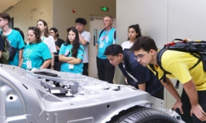 Sinh viên nước ngoài xem nền tảng Modena khi tham quan Nhà máy ô tô Xiaomi vào hồi tháng 6/2025 tại Bắc Kinh, Trung Quốc.