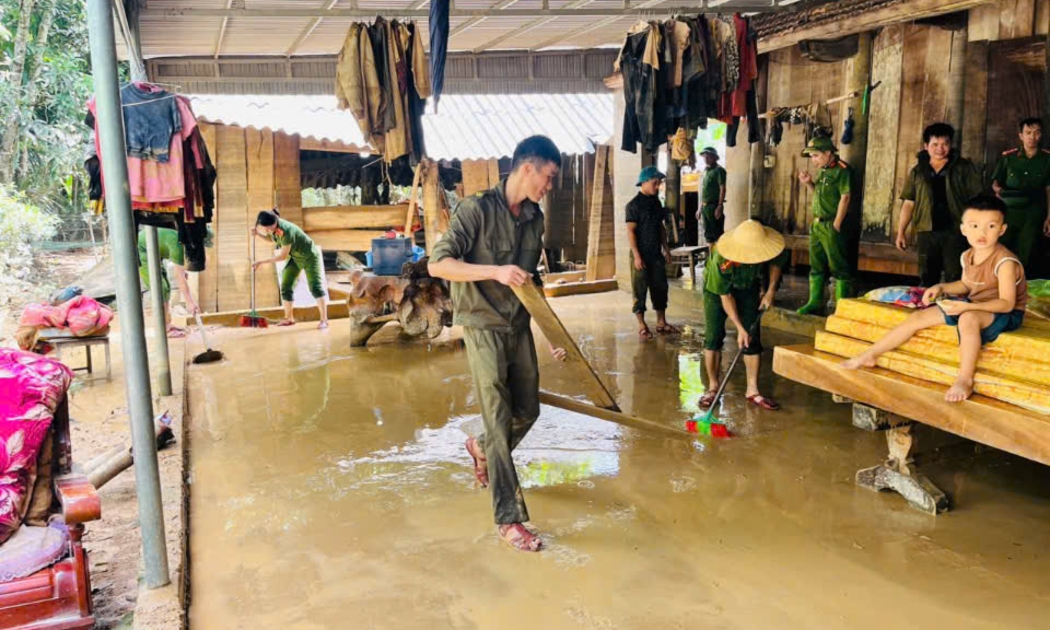 Lực lượng chức năng địa phương cùng các hộ dân dọn bùn đất trong sân nhà sau khi nước lũ rút.