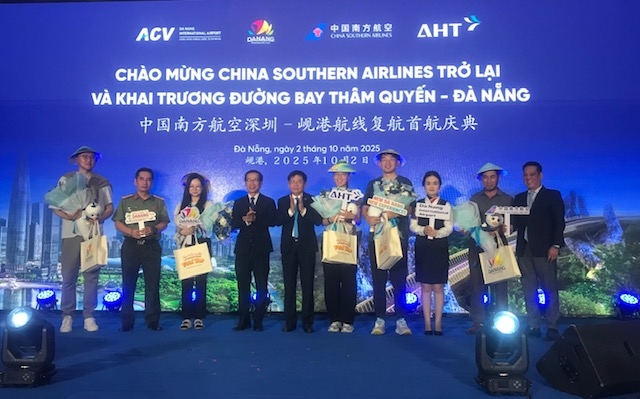 Những hành khách đầu tiên trên chuyến bay mang số hiệu CZ8155 của Hãng hàng không China Southern Airlines được lãnh đạo ngành Du lịch và Hàng không Đà Nẵng chào đón tặng quà lưu niệm. Ảnh Ngô Anh Văn