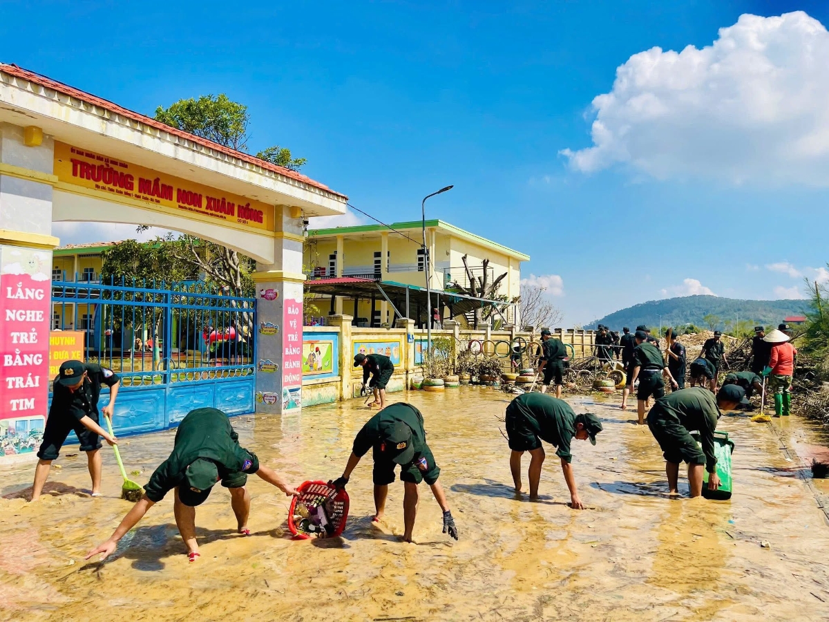 Dưới cái nắng hanh sau lũ, các chiến sĩ hối hả nhặt rác, tát nước, lau bùn, dọn sạch khuôn viên trường học.