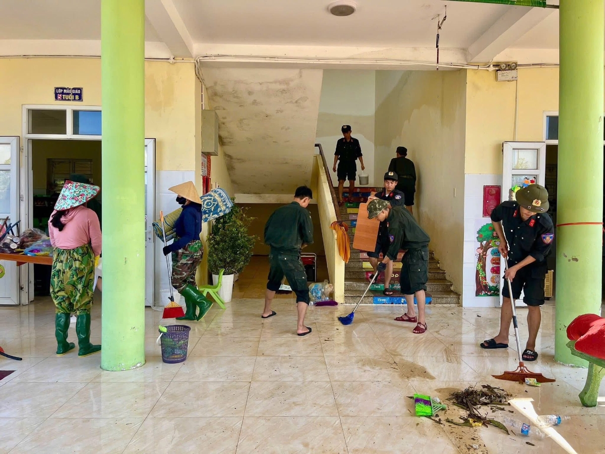 Những người lính trẻ cùng các cô giáo tích cực lau rửa khuôn viên trường cho các em học sinh mầm non.