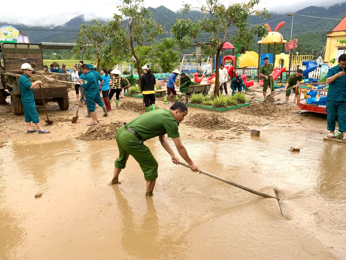 Cán bộ, chiến sĩ Công an xã cùng lực lượng quân sự và Đoàn Thanh niên xã Xuân Chinh (Thanh Hoá) tích cực thu dọn bùn đất trong khuôn viên Trường Mầm non Liên Sơn sau bão.