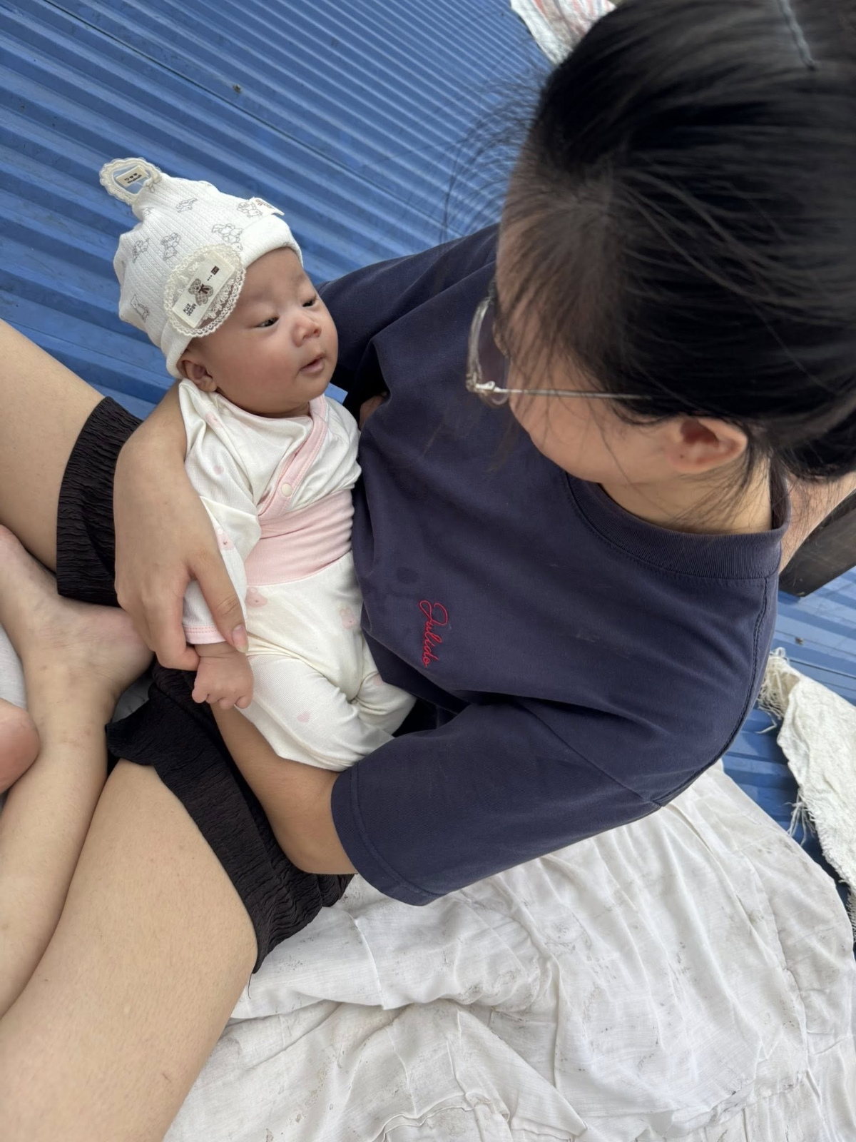 Một em bé ít ngày tuổi được mẹ đưa lên mái nhà tránh lũ.