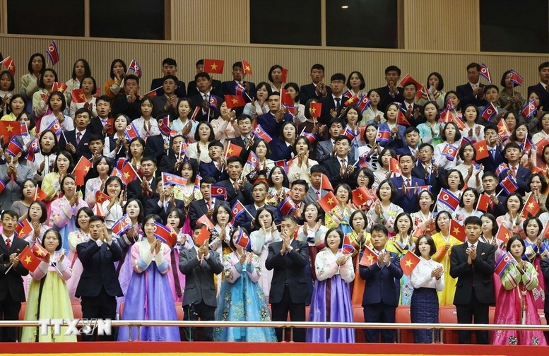 Trên khán đài, quần chúng nhân dân, hân hoan giơ cao vẫy cờ hai nước và hô vang chào đón Tổng Bí thư Tô Lâm và Đoàn đại biểu cấp cao Việt Nam. Ảnh: TTXVN.