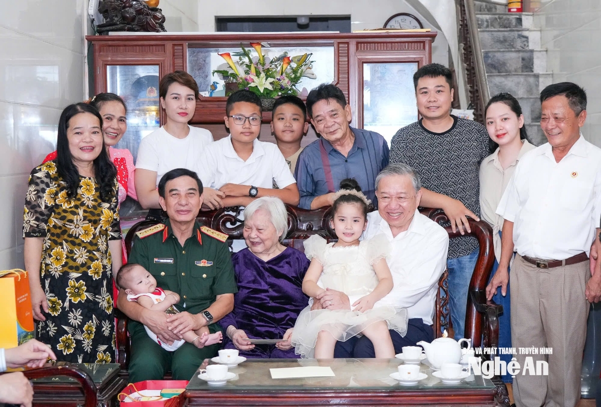 Đồng chí Tổng Bí thư Tô Lâm và Đại tướng Phan Văn Giang - Bộ trưởng Bộ Quốc phòng chụp ảnh lưu niệm cùng đại gia đình Mẹ Việt Nam anh hùng Nguyễn Thị Kim Oanh. Ảnh: Thành Cường