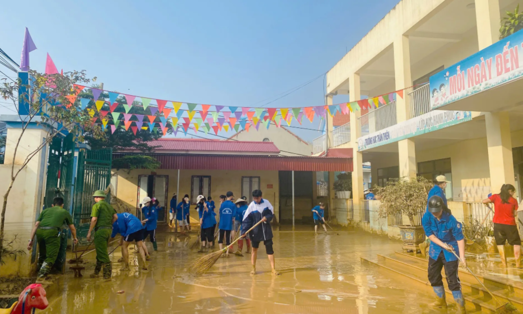 Học sinh ở Bắc Ninh dọn bùn đất sân trường sau đợt lũ dữ.