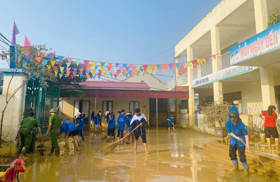 Học sinh ở Bắc Ninh dọn bùn đất sân trường sau đợt lũ dữ.