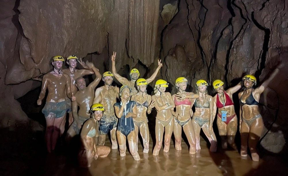 Du khách nước ngoài trải nghiệm hoạt động tắm bùn tự nhiên sâu bên trong hang động tại Khu du lịch Sông Chày.
