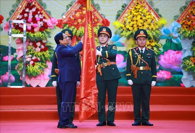 Thủ tướng Phạm Minh Chính gắn Huân chương Hồ Chí Minh lên Cờ truyền thống của Quân khu 5.&nbsp;Ảnh: TTXVN