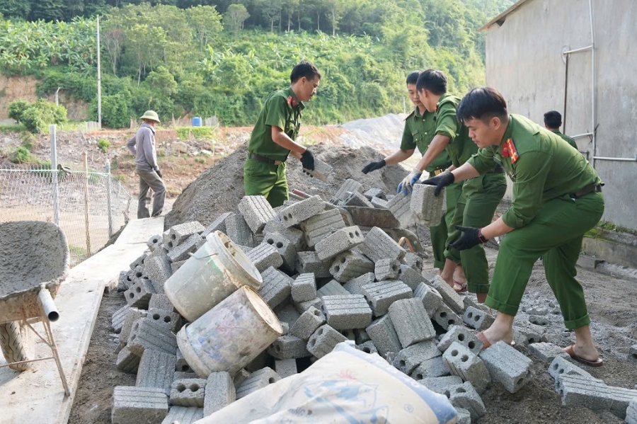 Các cán bộ chiến sĩ công an phối hợp với đơn vị thi công đẩy nhanh tiến độ, kịp hoàn thành và bàn giao nhà cho người dân tại các xã vùng cao Nghệ An bị thiệt hại do bão lũ