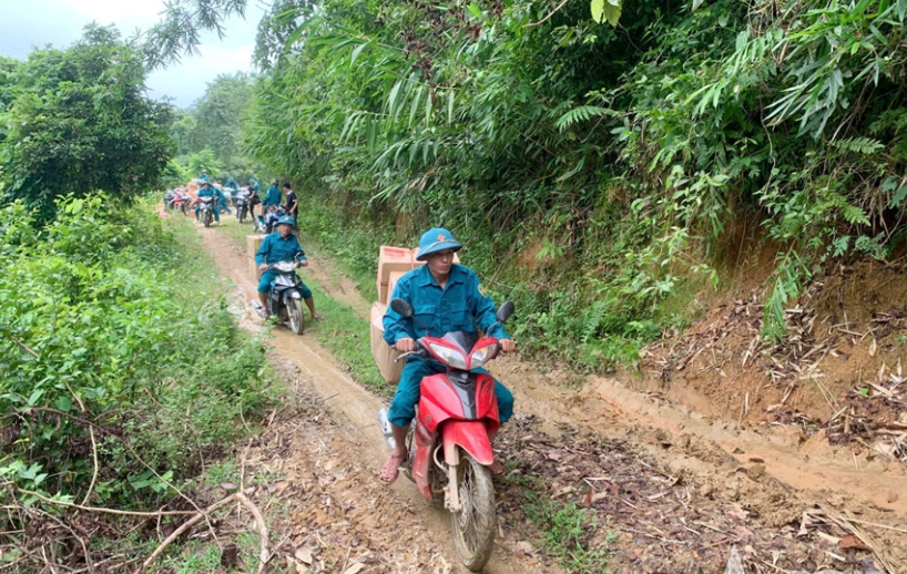 Lực lướng chức năng sử dụng xe máy để vận chuyển lương thực vào các bản bị cô lập ở xã Nga My 