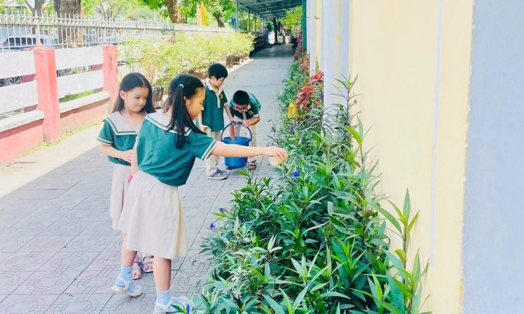 Học sinh Trường Tiểu học Lê Lợi (thành phố Huế) tập cách chăm sóc xanh tại trường học. Ảnh: Văn Dinh.